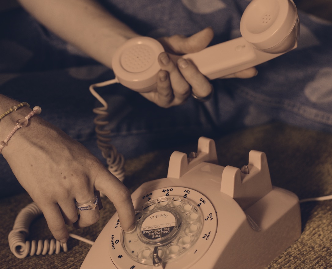 Two hands dialling a rotary telephone