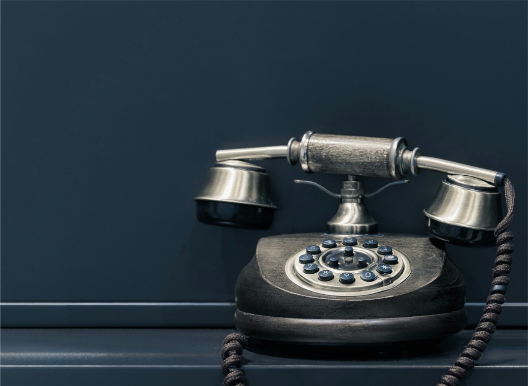 A vintage telephone on a dark blue wall